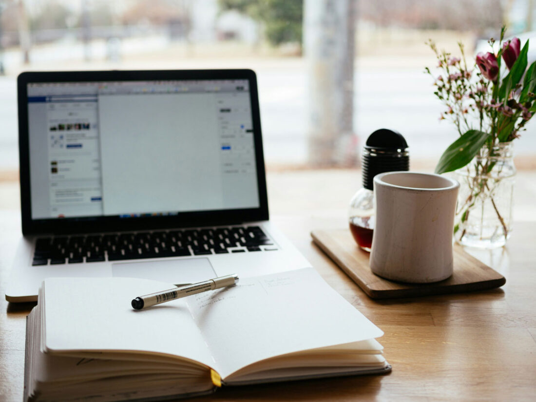 Make an appointment for bookkeeping services - laptop, notes, coffee mug on desk.