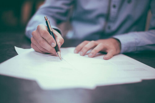 Payroll services - man writing with pen